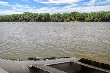 The rubber boat on the river bank in the summer afternoon (2).