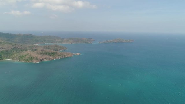 Aerial view of coast with beaches, island Limbones, lagoons and coral reefs. Neela cove, Philippines, Luzon. Coast ocean with turquoise water. Tropical landscape in Asia.