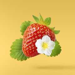 Flying Fresh tasty ripe strawberry with green leaves