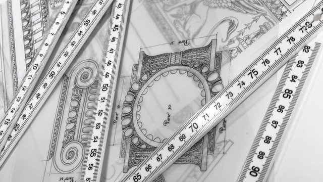 Blueprints - architectural drawings, yardstick - folding ruler smoothly rotate on the surface of the drawings of antique decorative elements of architectural orders