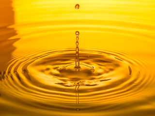 close up of a drop oil on a yellow background