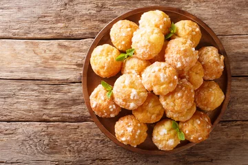 Foto op Plexiglas Chouquettes French Cream Puffs dessert is decorated with pearl sugar and mint closeup. Horizontal top view © FomaA