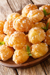 French dessert chouquette profiteroles with pearly sugar and mint closeup. vertical