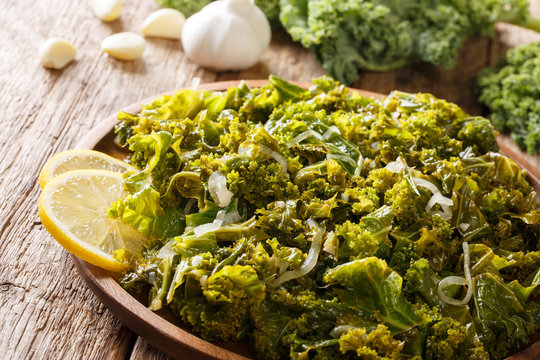 Delicious kale, onions, garlic and lemon close-up on a plate and ingredients. horizontal