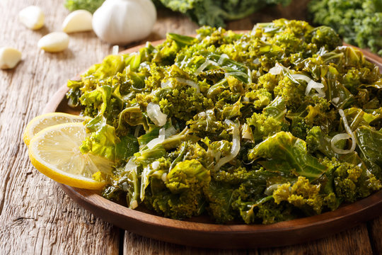 Healthy diet foods: kale, onion and garlic and lemon close-up on a plate. horizontal