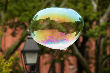 colorful flying soap bubble with city reflection