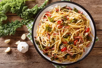 Photo sur Plexiglas Plats de repas Déjeuner italien de pâtes au chou frisé, bacon, tomates et parmesan en gros plan. Vue de dessus horizontale