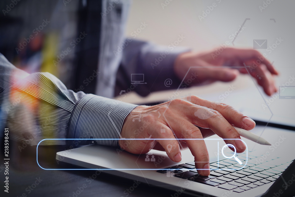 Poster close up of businessman working with mobile phone and stylus pen and laptop computer on wooden desk 