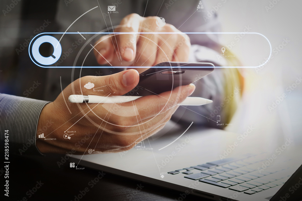 Poster close up of businessman working with mobile phone and stylus pen and laptop computer on wooden desk in modern office