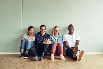 Diverse businesspeople laughing together while sitting on an off