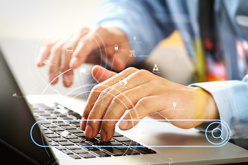 close up of businessman typing keyboard with laptop computer on wooden desk in modern office with...