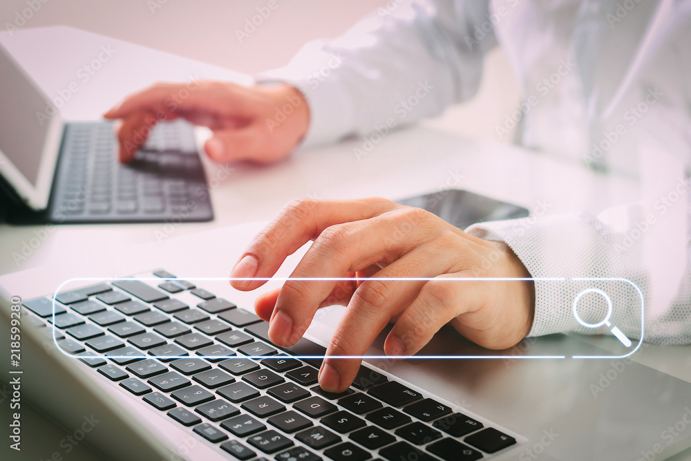 Poster close up of businessman typing digital tablet with keyboard and laptop computer on white desk in modern office