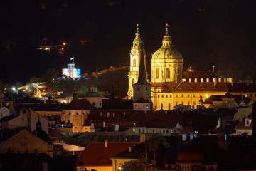 Fototapeta na wymiar Night landscape or cityscape of historical downtown of the Prague, quarter Mala strana and rooftops, with Saint Nicolas church, oldest part of city by Prague castle