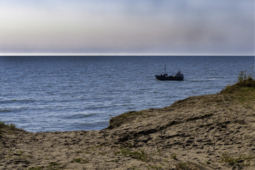 Obraz premium a small boat floating on the blue sea