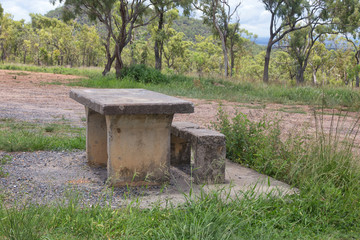 Fototapeta na wymiar Decaying concrete picnic table and bench on the Atherton Tableland in Queensland, Australia