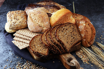 Sliced rye bread on cutting board. Whole grain rye bread and rolls with seeds.