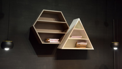 Modern wooden shelves on dark grey wall brick backgrond with fashion lamps. Trendy design