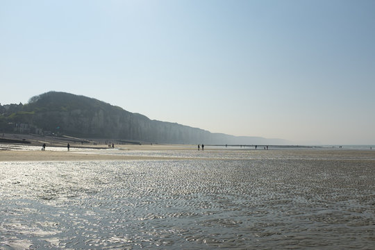 People on a misty beach at low tide