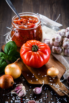 Raw tomatoes and tomato sauce in jar