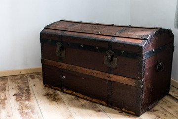 dark wood trunk in a country house. antique treasure chest with metal hinges to store clothes and materials