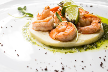 Shrimp with lime on a white plate close-up