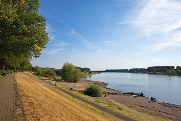 Scenery of beach and riverside on sunny day. People enjoy natural landscape at the beach around...