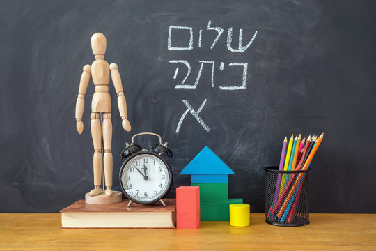 Back to school concept. The inscription in Hebrew Back to school on chalkboard background.