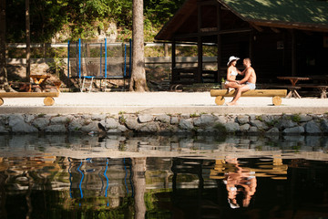 Active couple rests on river bank on a hot summer day