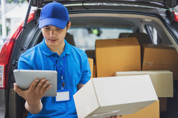 Delivery man checking list on tablet.