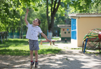 Belarus, Gomel, May 29, 2018. The kindergarten is central. Open Day.A boy in a kindergarten is playing outside. The baby catches the May bug.