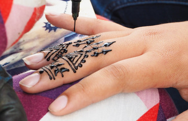 Henna tattoos being put on hands in Morocco