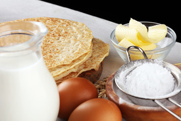 Homemade crepes served with fresh raspberrries and powdered sugar on rustic table.