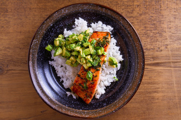 Avocado salmon rice bowl. Salmon fillet roasted in honey, lime, cilantro glaze and fresh cilantro avocado. Fish steak. View from above, top studio shot