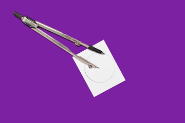 metal calipers and a memorandum white paper lying on a purple background . concept of office...