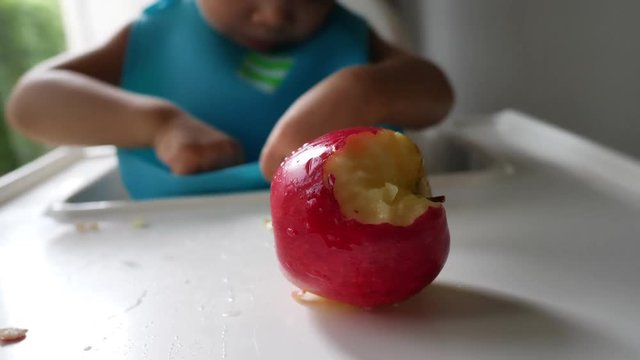 first time, cute child eating bite red apple