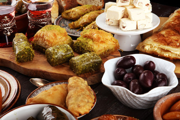 Middle eastern or arabic dishes and assorted meze, concrete rustic background. sambusak. Turkish Dessert Baklava with pistachio. Sarma. Halal food. Lebanese