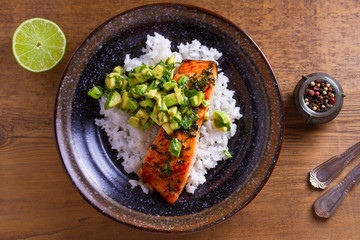 Avocado salmon rice bowl. Salmon fillet roasted in honey, lime, cilantro glaze and fresh cilantro avocado. Fish steak. View from above, top studio shot
