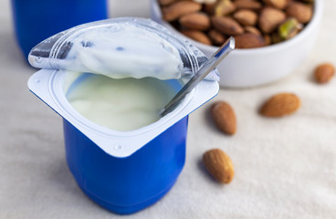 A breakfast of yogurt and a spoon placed on a wood table.