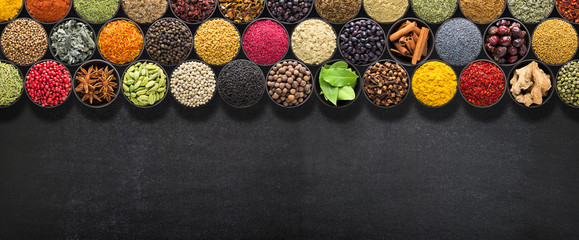 Spices and herbs for European food. Seasoning on  black table with space for recipe or text.
