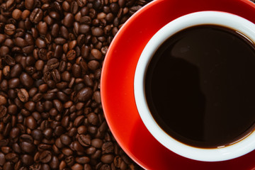 Red coffee cup with coffee beans .