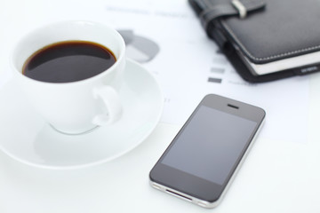 Business concept shot with coffee, phone and planner on table