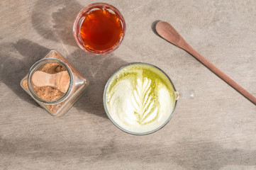 Top view of  hot  Matcha green tea latte served with pure hot tea and brown sugar on the wood table.
