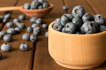 Fresh blueberries on a wooden table in a wooden plate. Close up. The concept of natural food