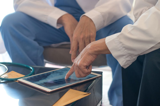 Digital health and teamwork concepts. Doctor physician work together with Anesthesiologists using tablet to view medical x-ray images of patient in hospital.