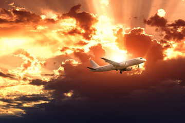 Fototapeta na wymiar Airplane on the rainy cloudy sky background. The sun's rays make their way through the clouds. 