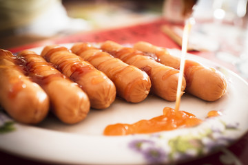Steamed sausage, topped with ketchup, chili sauce