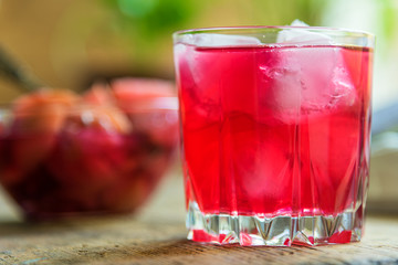 Red fruit drink with ice on a rustic background