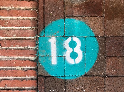 Stenciled number 18 in white in a turquois circle