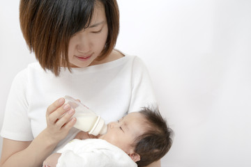 Obraz na płótnie Canvas 新生児にミルクを飲ませるお母さん