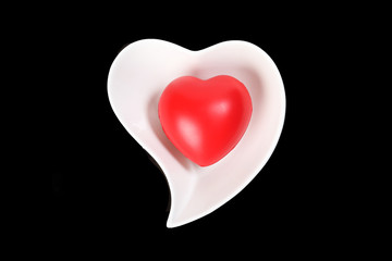 Hart Love shape plastic rubber object on white plate black background
